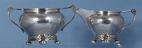 A George V planished silver Arts & Crafts sugar bowl and cream jug, by Albert Edward Jones, jug height 82mm, weight 10.3oz/321grms.